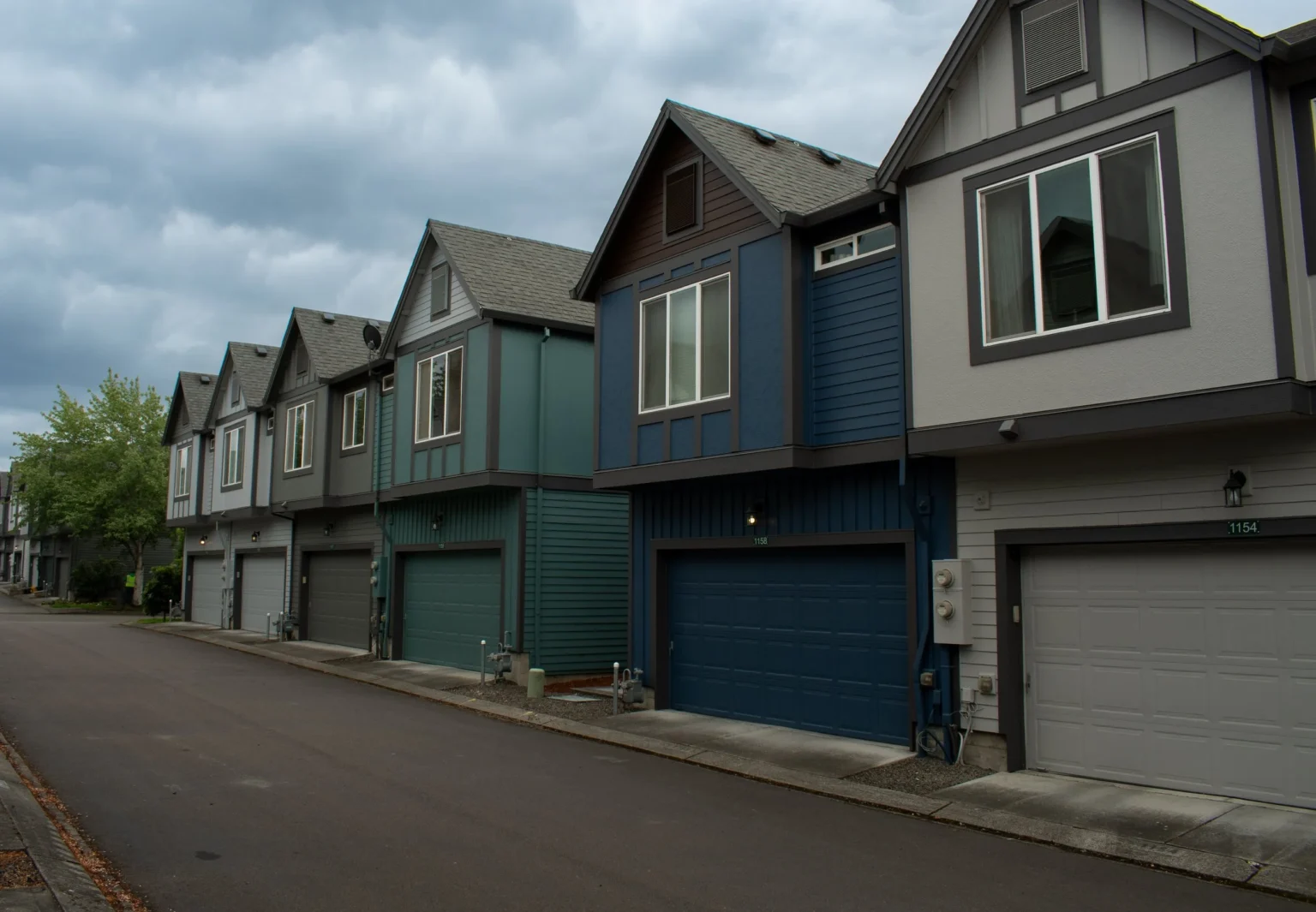 Townhome community repainted in a varied palette of green, blue and grey exteriors